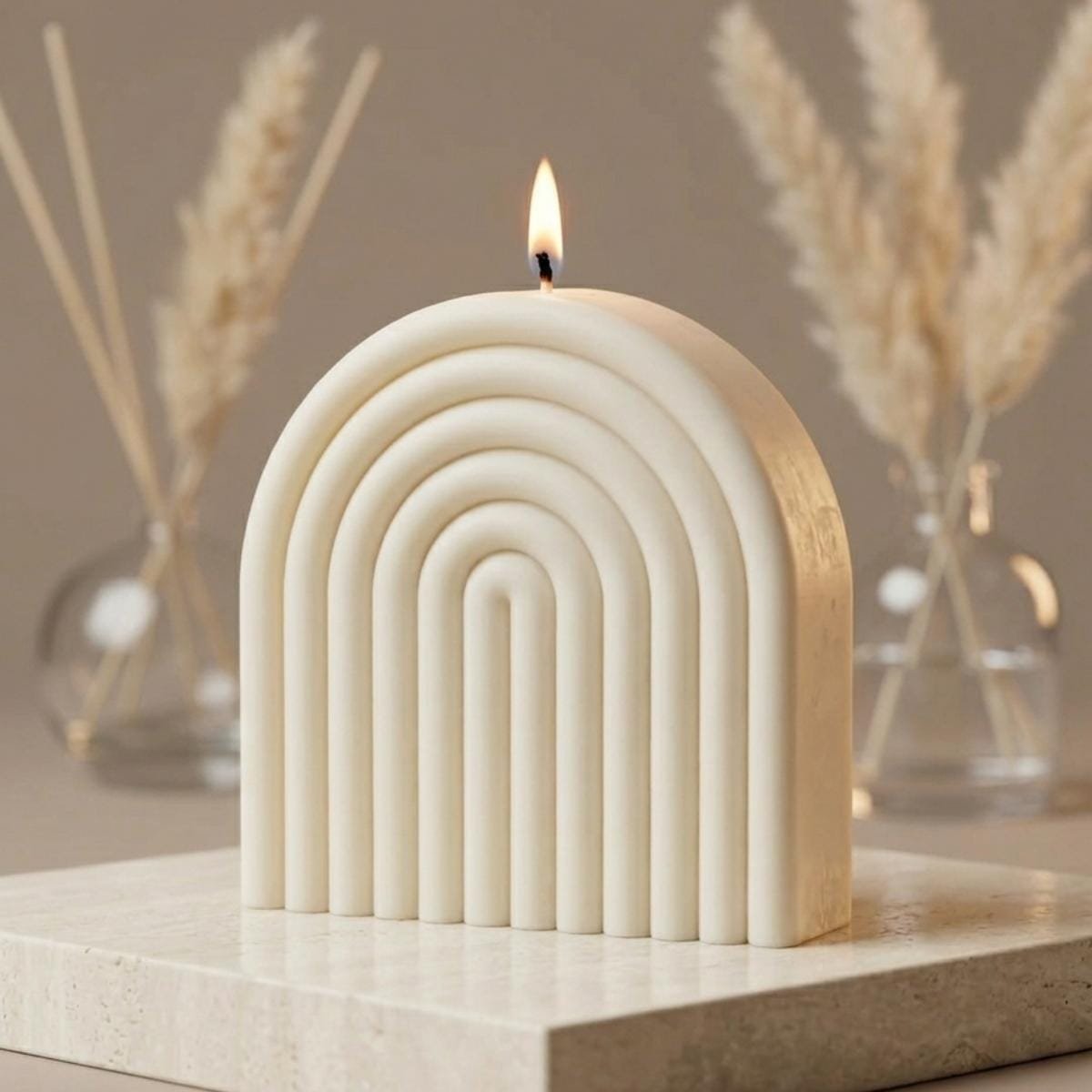 Notre approche de fabrication FAIT Main | Niõ 2 Mise en situation d'une bougie artisanale moulée de Niõ dans un décor minimaliste et chaleureux - illustration Fait Main de Niõ