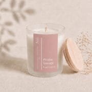 Visuel de la bougie parfumée Pivoine Sauvage avec son couvercle en bois naturel posé dans un cadre épuré et bohème