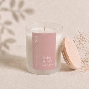 Visuel de la bougie parfumée Pivoine Sauvage avec son couvercle en bois naturel posé dans un cadre épuré et bohème