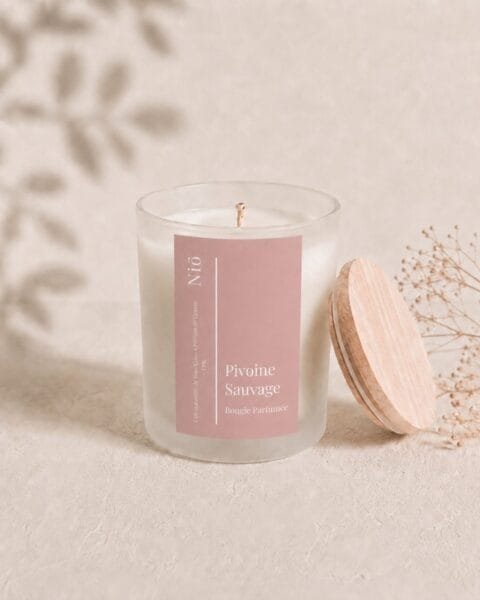 Visuel de la bougie parfumée Pivoine Sauvage avec son couvercle en bois naturel posé dans un cadre épuré et bohème