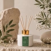 Diffuseur Bois Sacré de Niõ, au parfum d'ambiance Bois de Santal, dans un décor épuré, posé sur un socle de pierre naturelle
