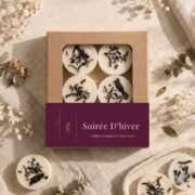 Belle composition de fondants parfumés Soirée d'Hiver de Niõ dans leur écrin avec l'étiquette, avec des épices hivernales et de Noel autour comme décor